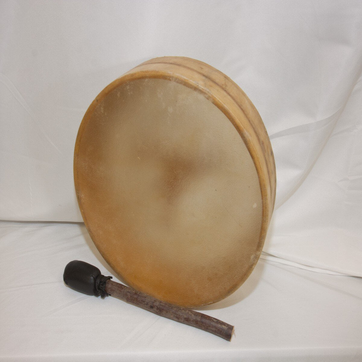 Roosebeck 12 inch antler handle frame drum standing upright with its beater