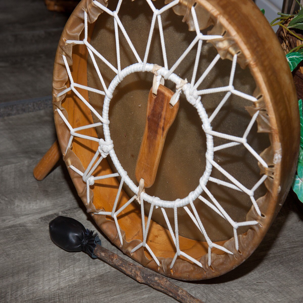 Back of the Roosebeck 14 inch frame drum showing the wooden handle, hoop and rawhide lacing