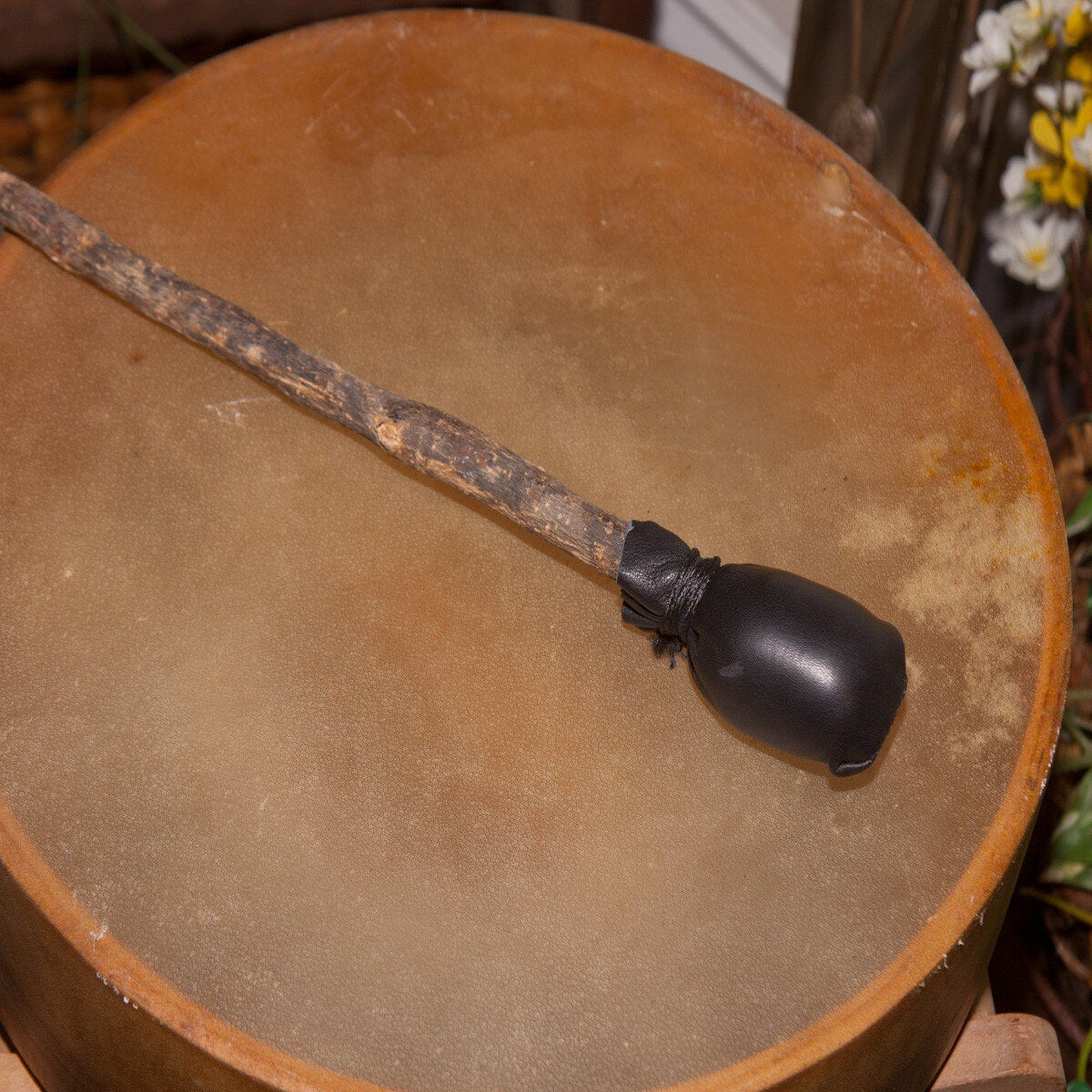 Calfskin head of the Roosebeck 14 inch wooden handle frame drum with its beater